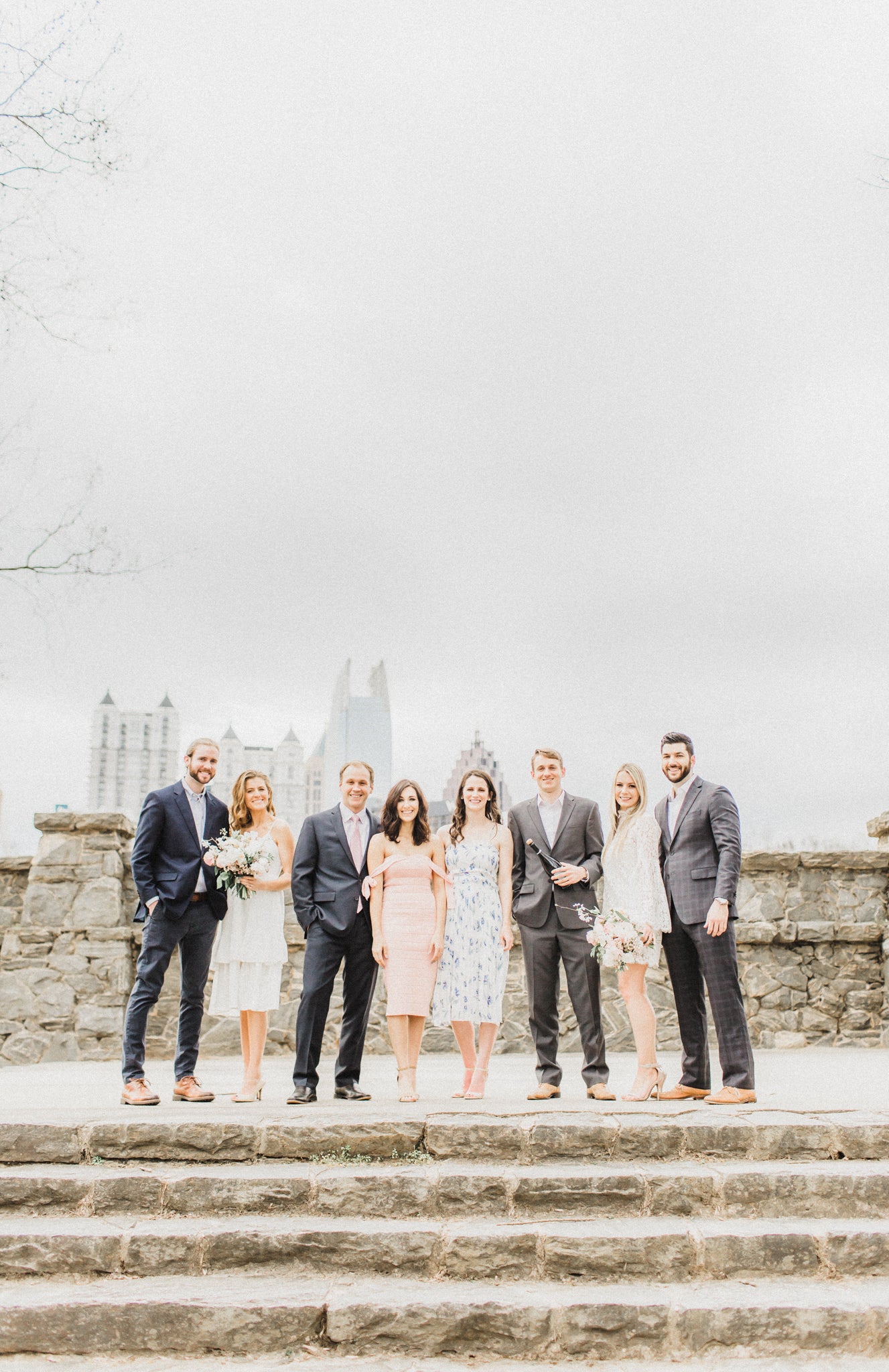 bridal party taking engagement photographs popping champagne holding bouquets