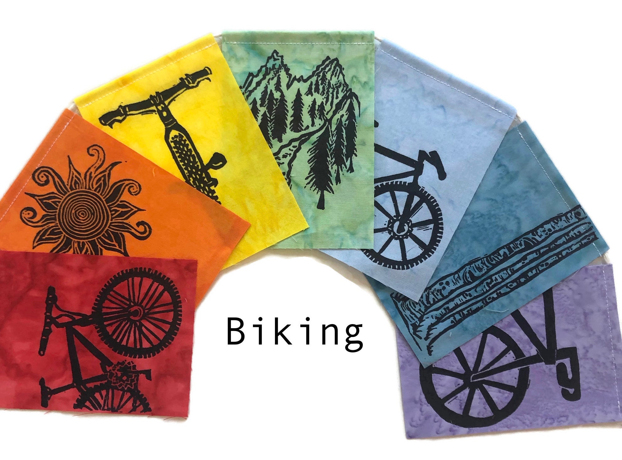 Rainbow flags with printed images of Bikes, a sun, mountain and aspen trees.