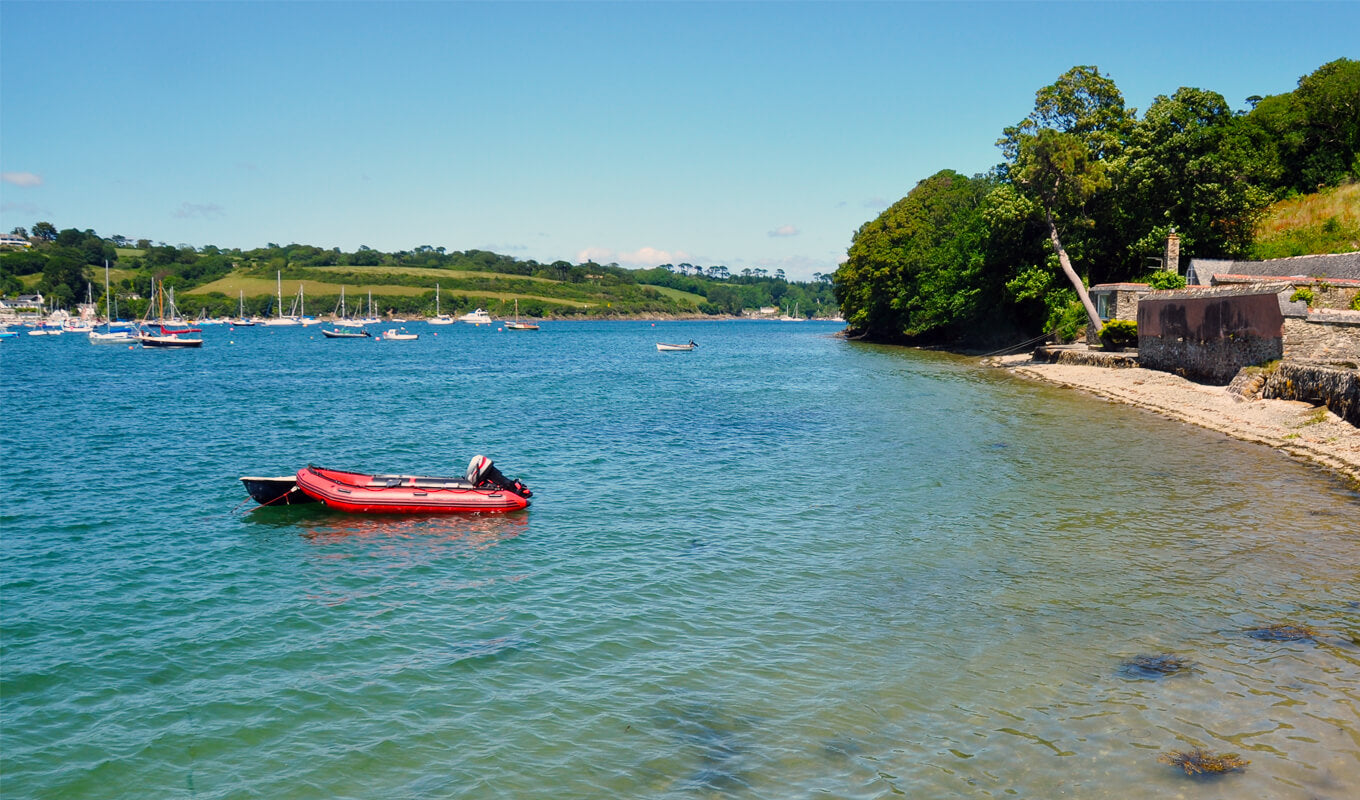 red inflatable multi person kayak on river helford cornwall