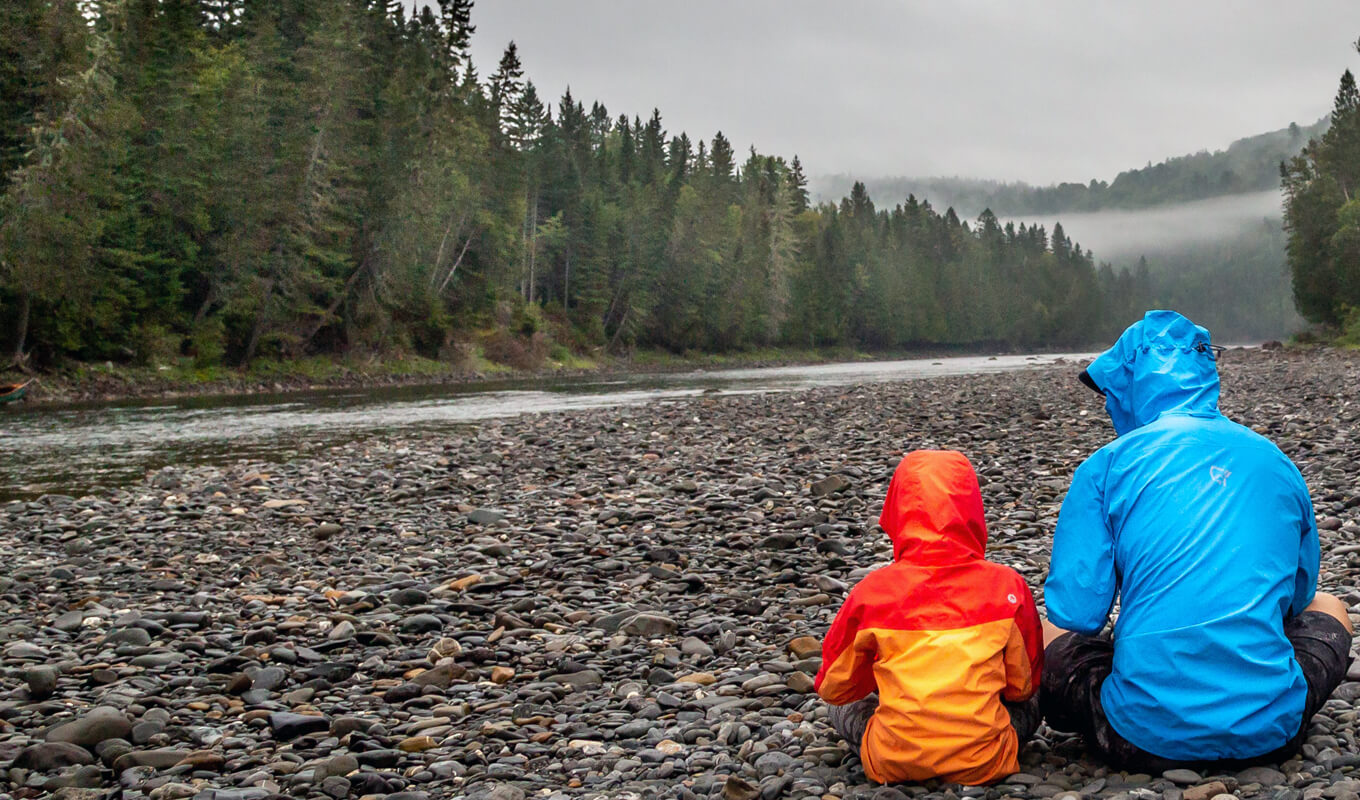 Man and a kid wearing jackets near, Bonaventure river Quebec