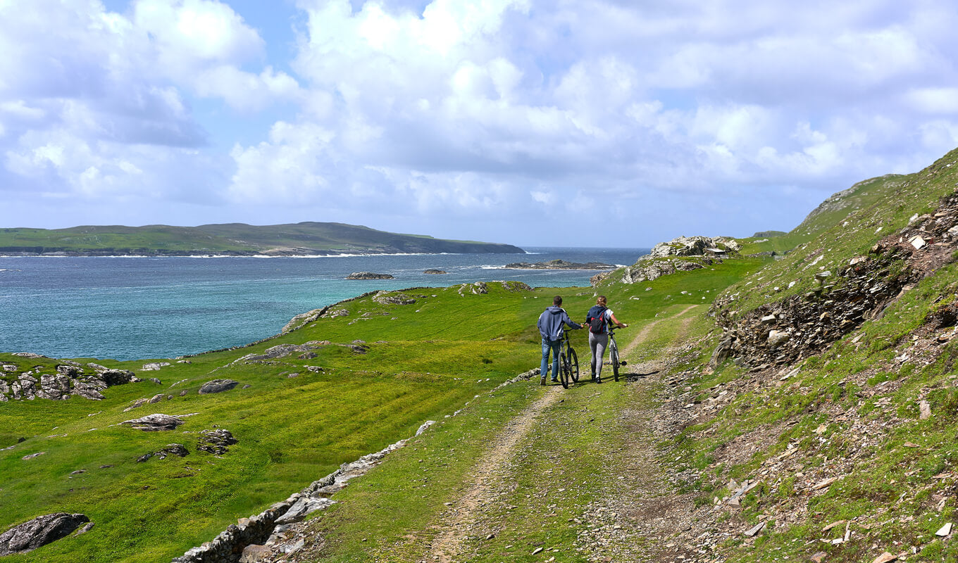 Two bikers with an aerial view of lake