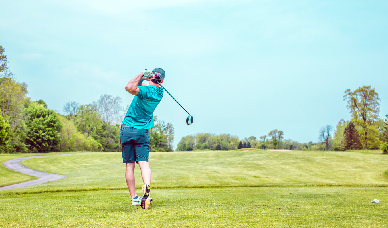 Man playing golf under the blue sky