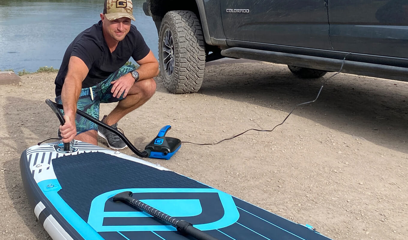 Man inflating sup board with 12V gili electric pump