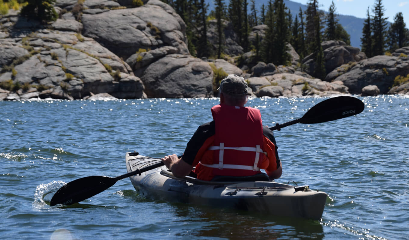 Man kayaking with life vest