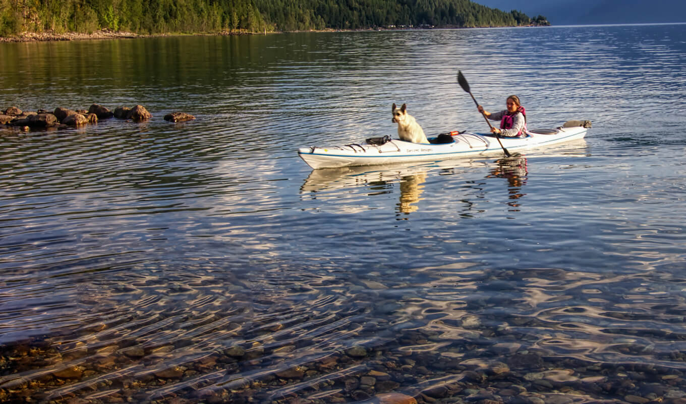 Woman paddling with her dog on a sit in kayak