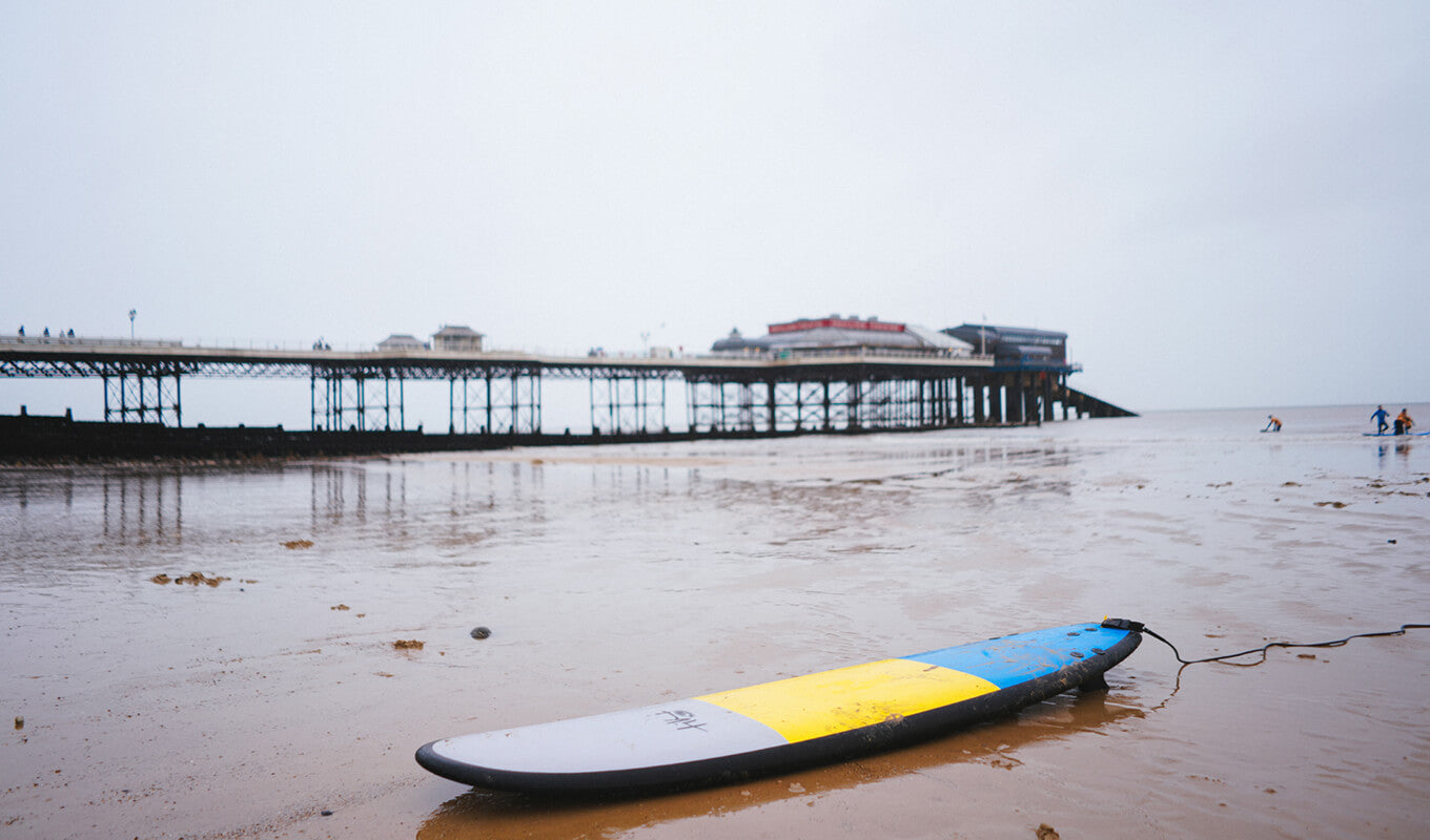 Yellow and blue soft top paddle board on the beach