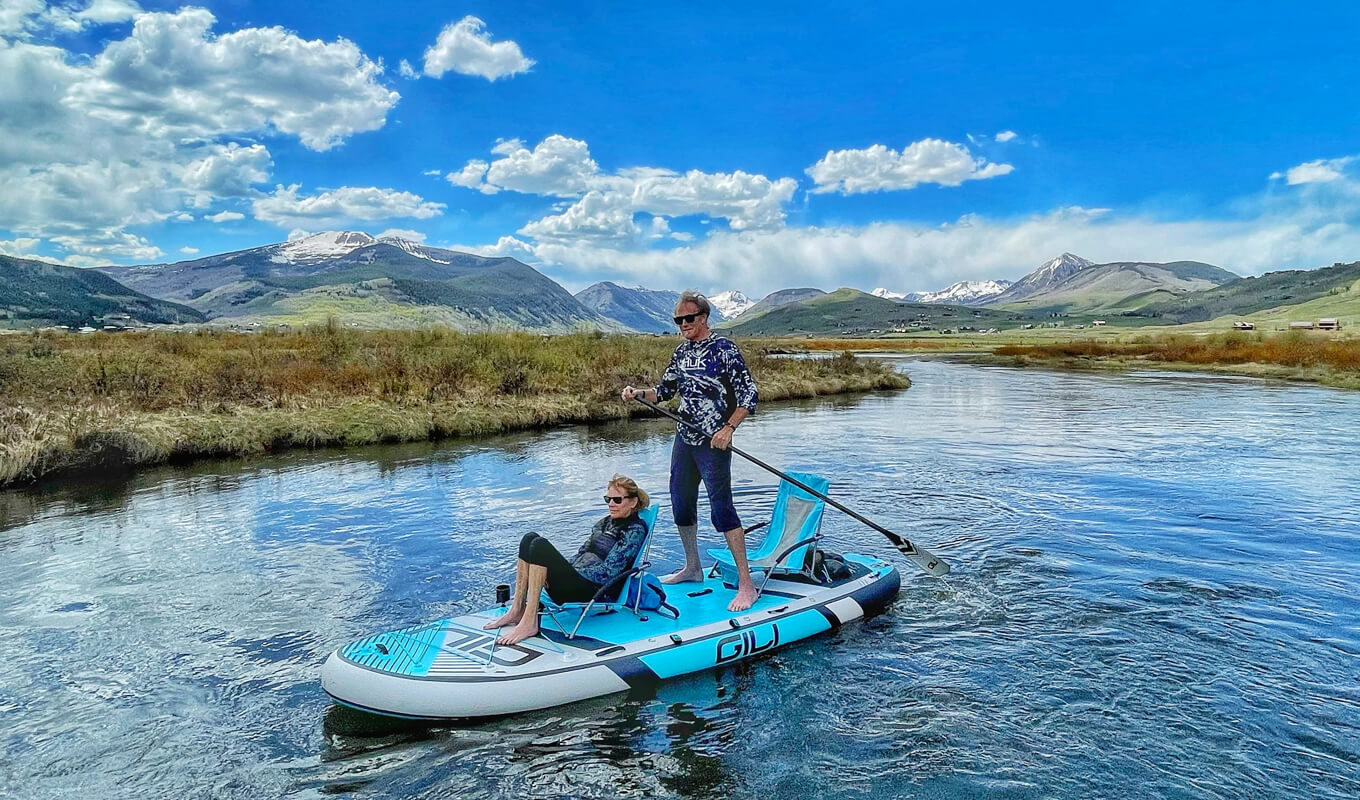 A couple wearing a polarized sunglasses SUPing a GILI manta board