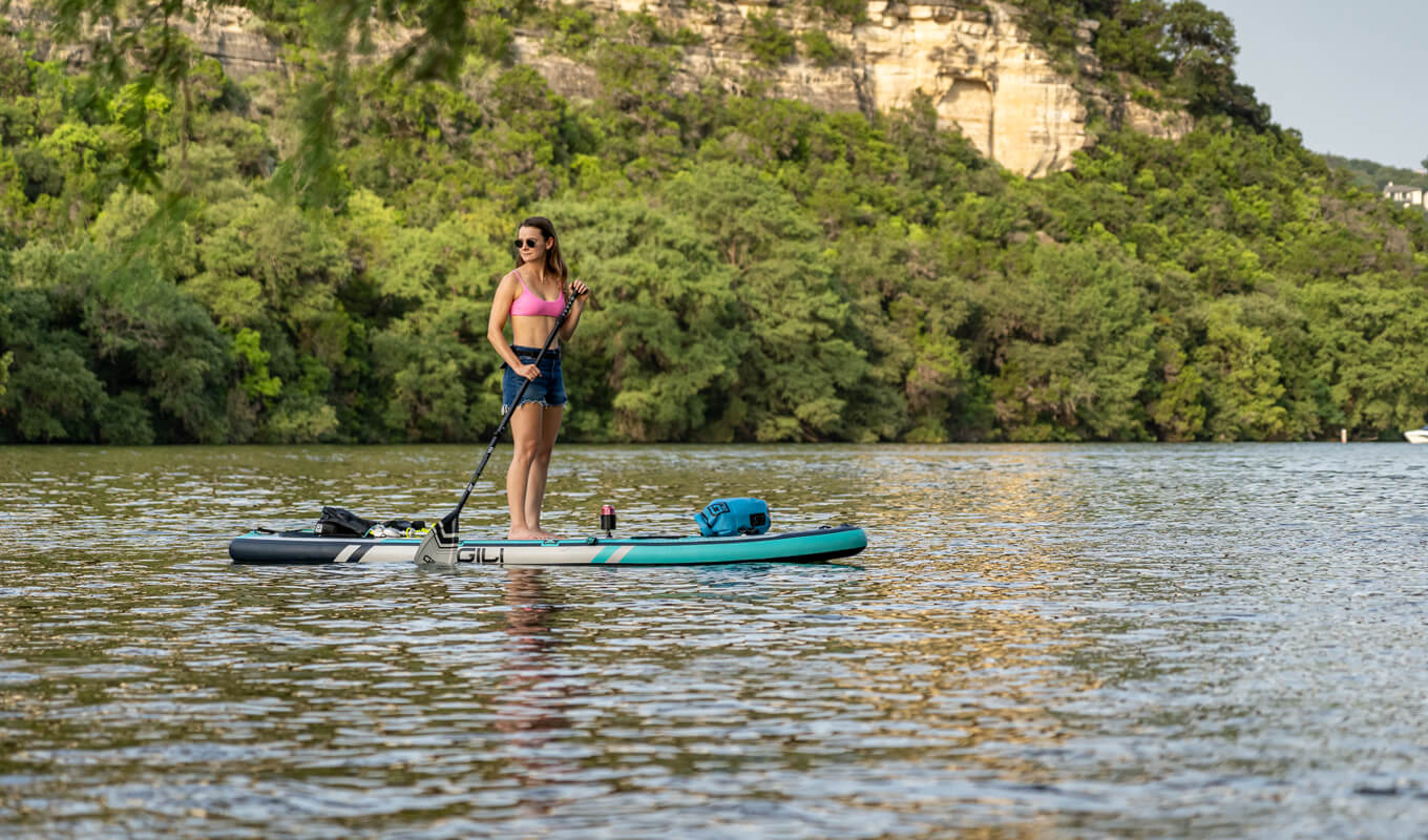 Woman paddle boarding on a pink top