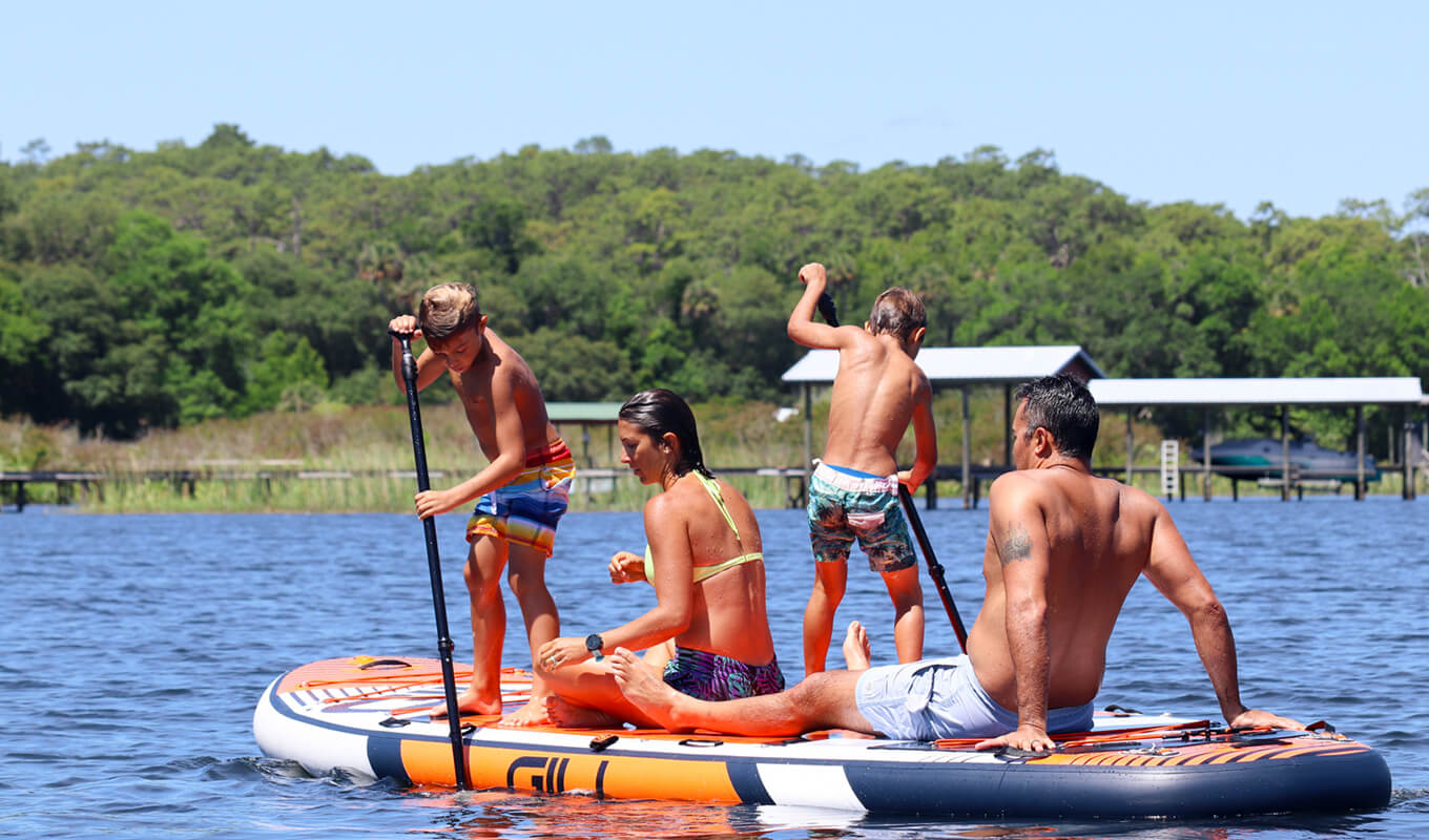 Couple paddle boarding with their kids on a GILI Manta board