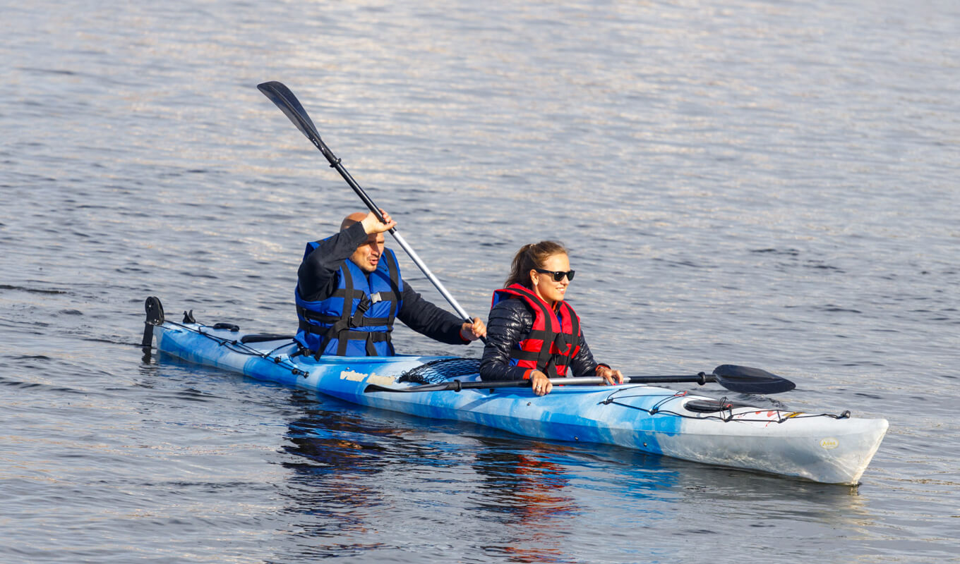 Man and woman paddling tandem kayak