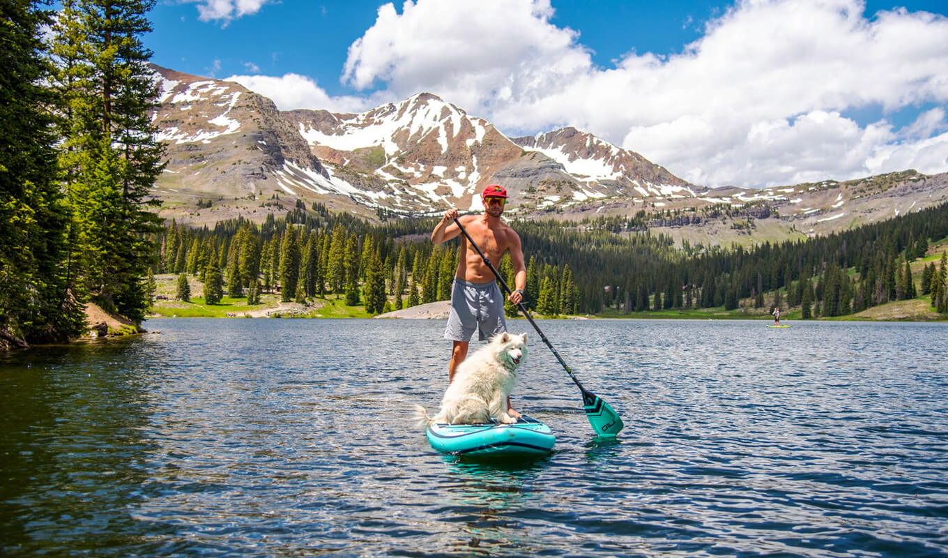 Mann paddelt mit seinem Hund auf dem Lake Irvin