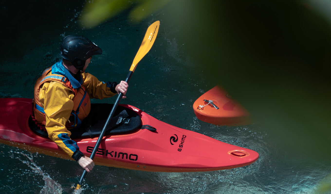 Man wearing of yellow and red life vest on a whitewater kayak