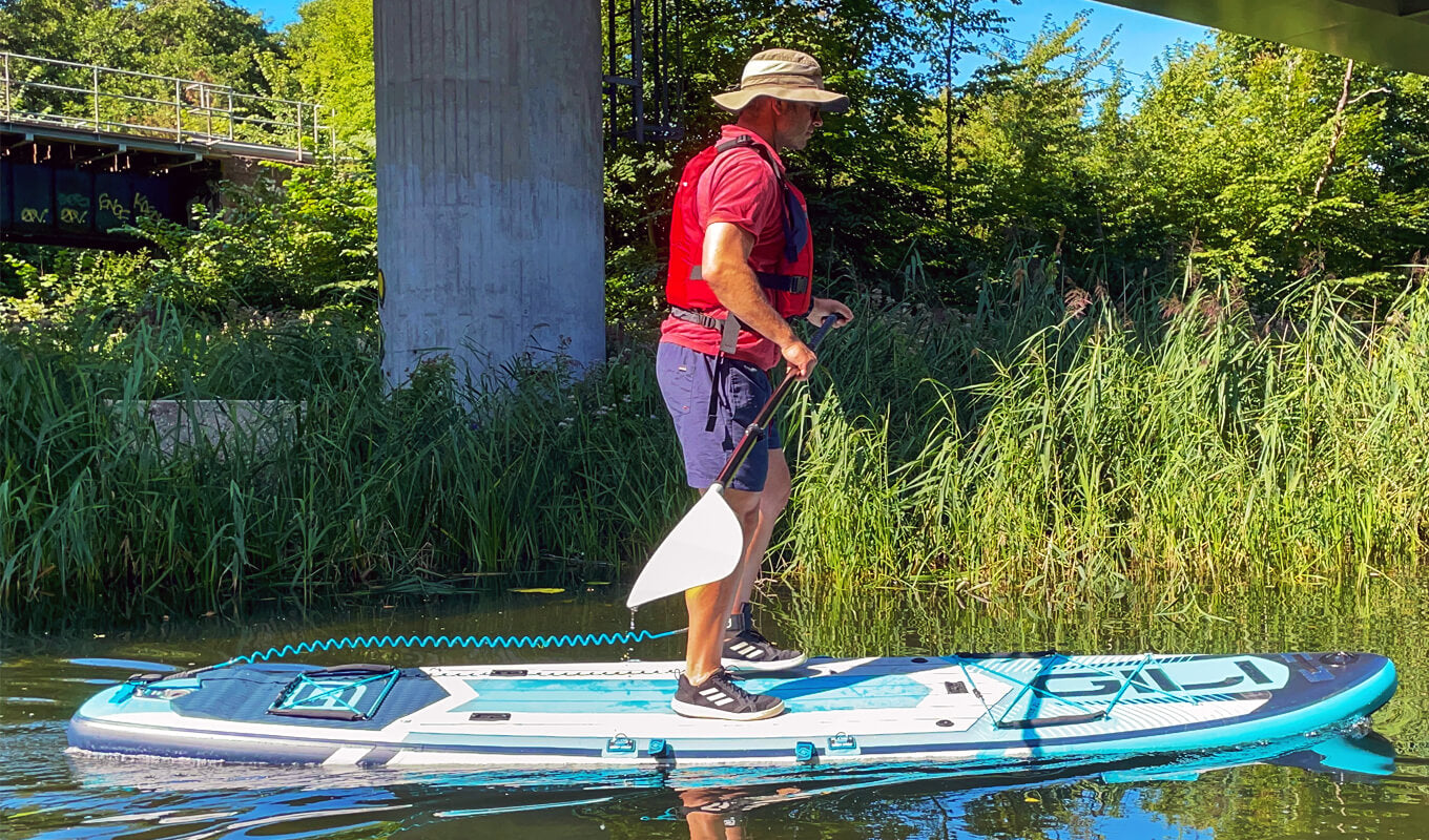 Man wearing a red life jacket paddling using GILI adventure paddle board