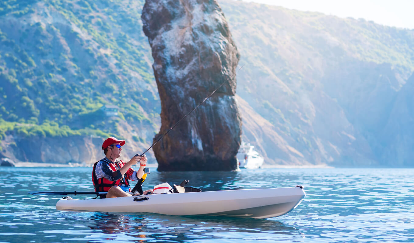 Man fishing on kayak while wearing life jackets