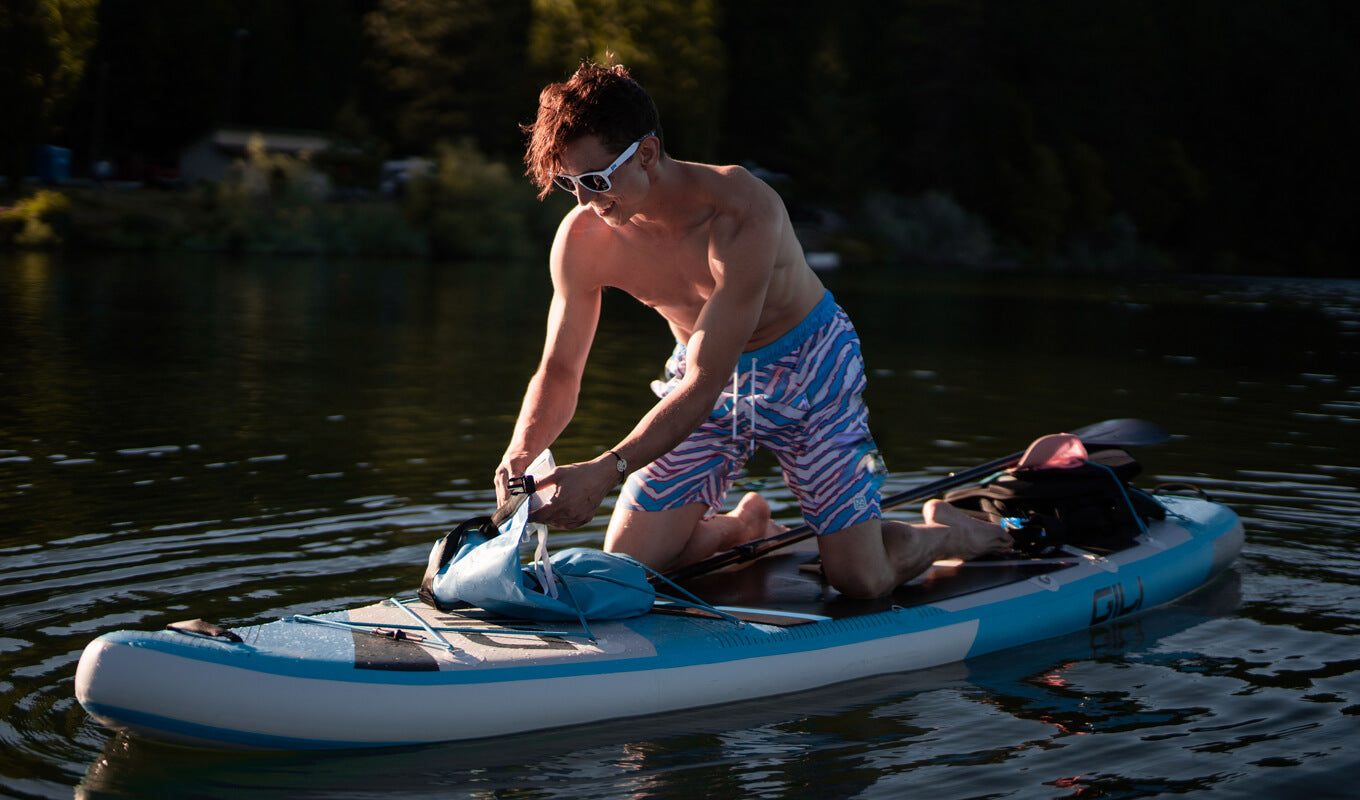 Mann fixiert Gili Dry Bag auf einem SUP