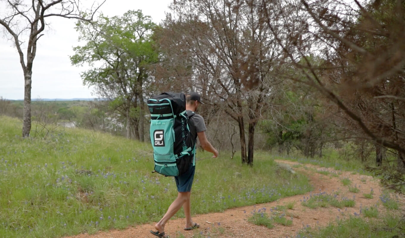 Man carrying a blue backpack and a fishing rod