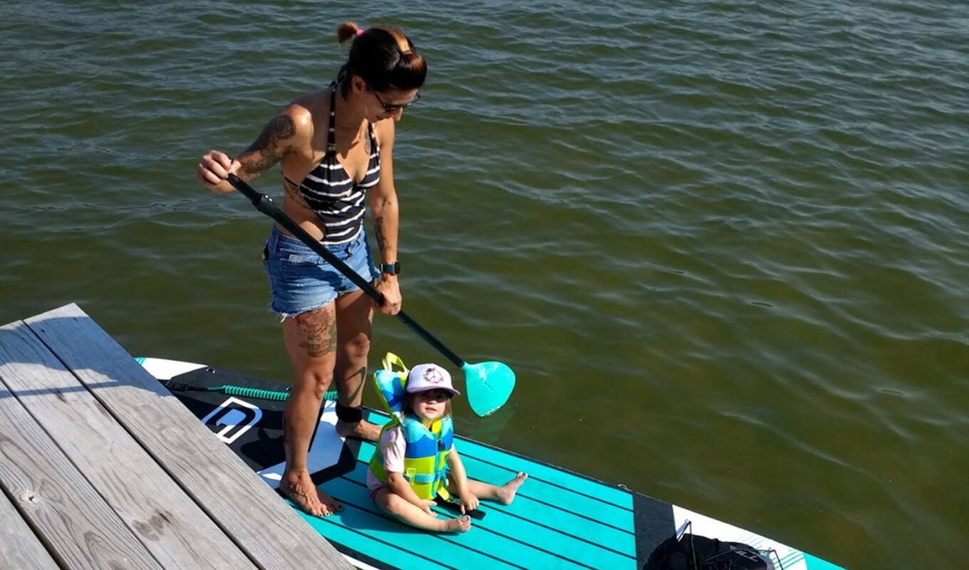 Woman with her child sitting on a GILI paddle board