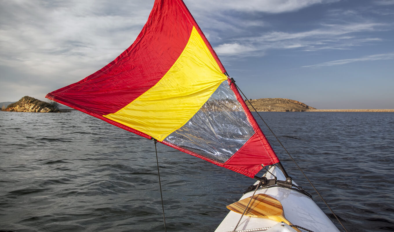 Red and yellow sail attached to a kayak