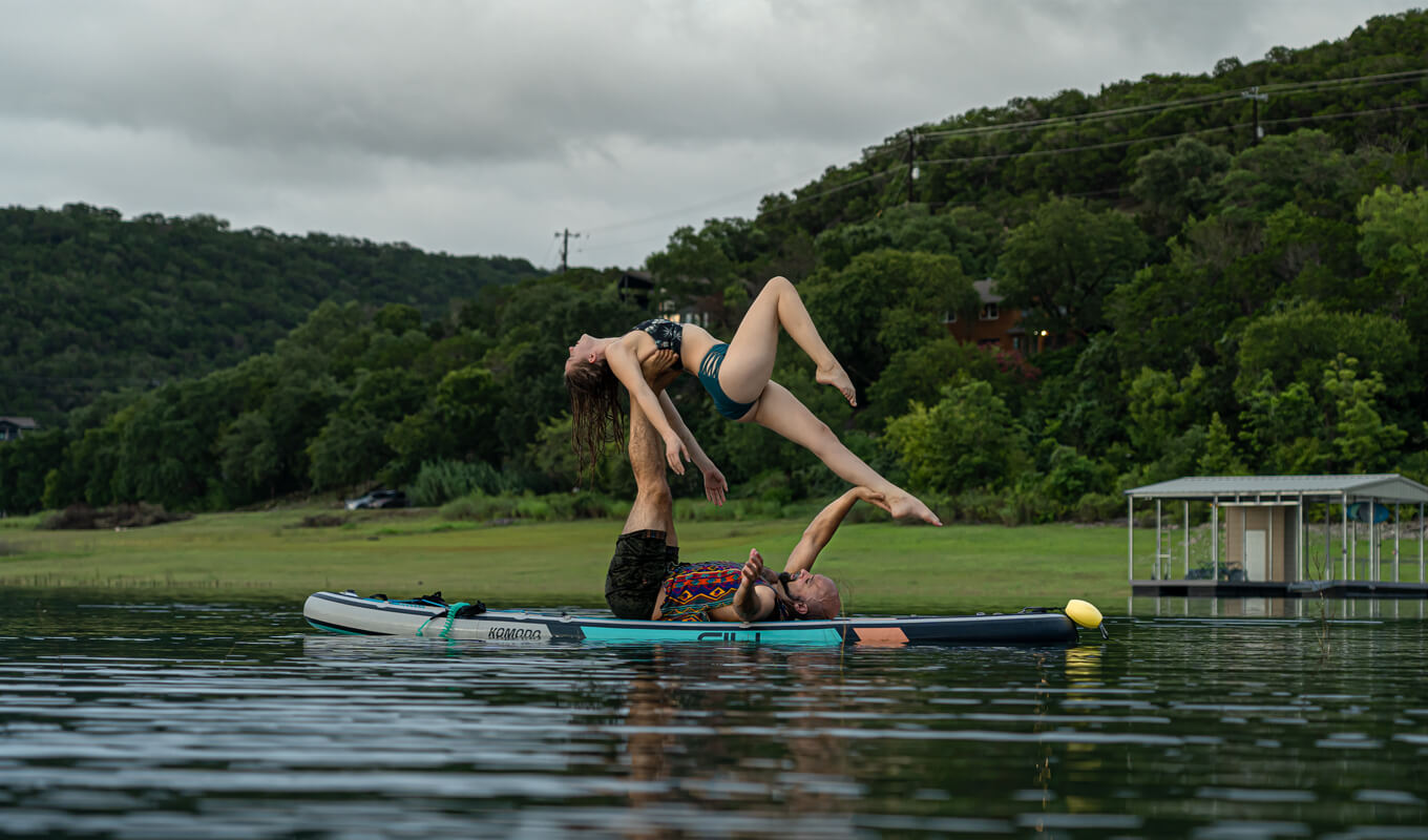 Man and woman yoga pose on a komodo board