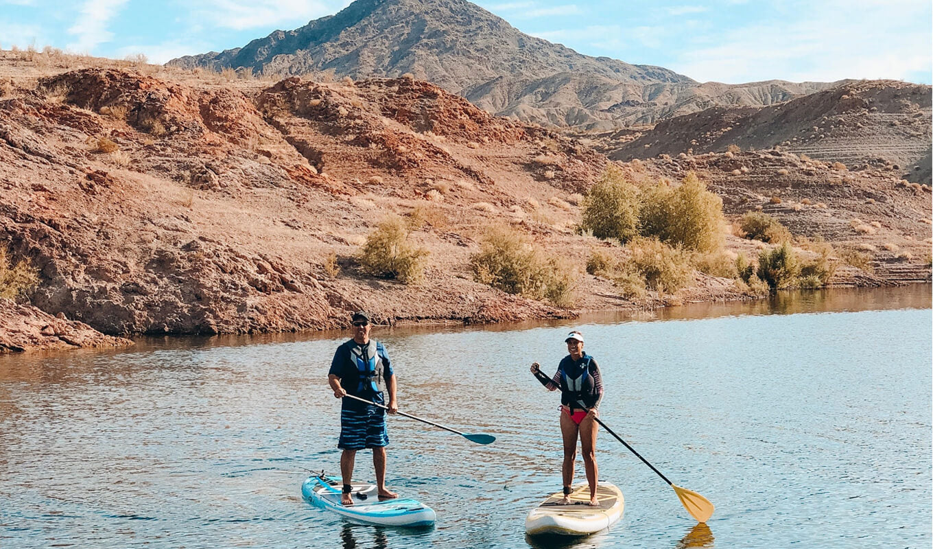 Man and a woman paddle boarding on a body of water