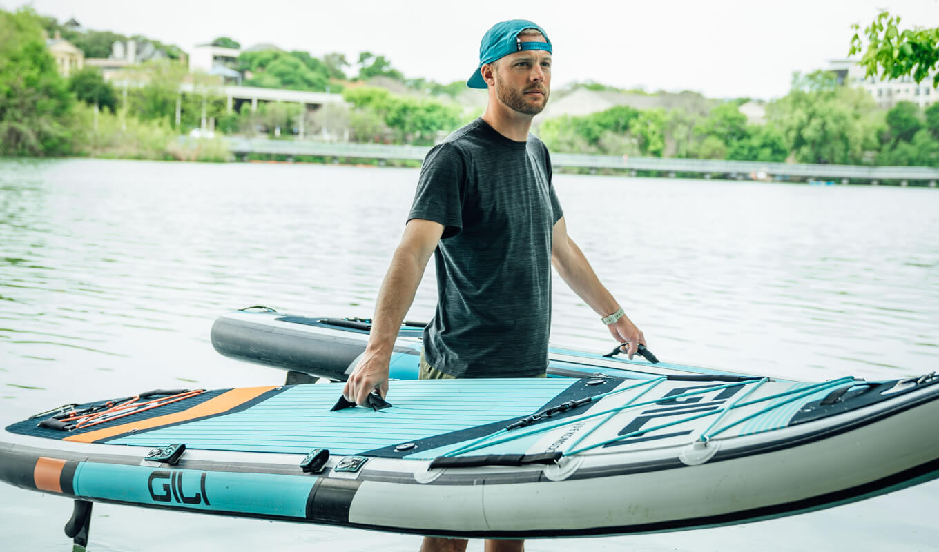 Man holding two inflatable paddle boards