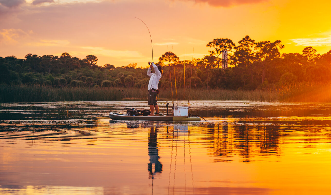 Man fishing on a paddle board with accessories