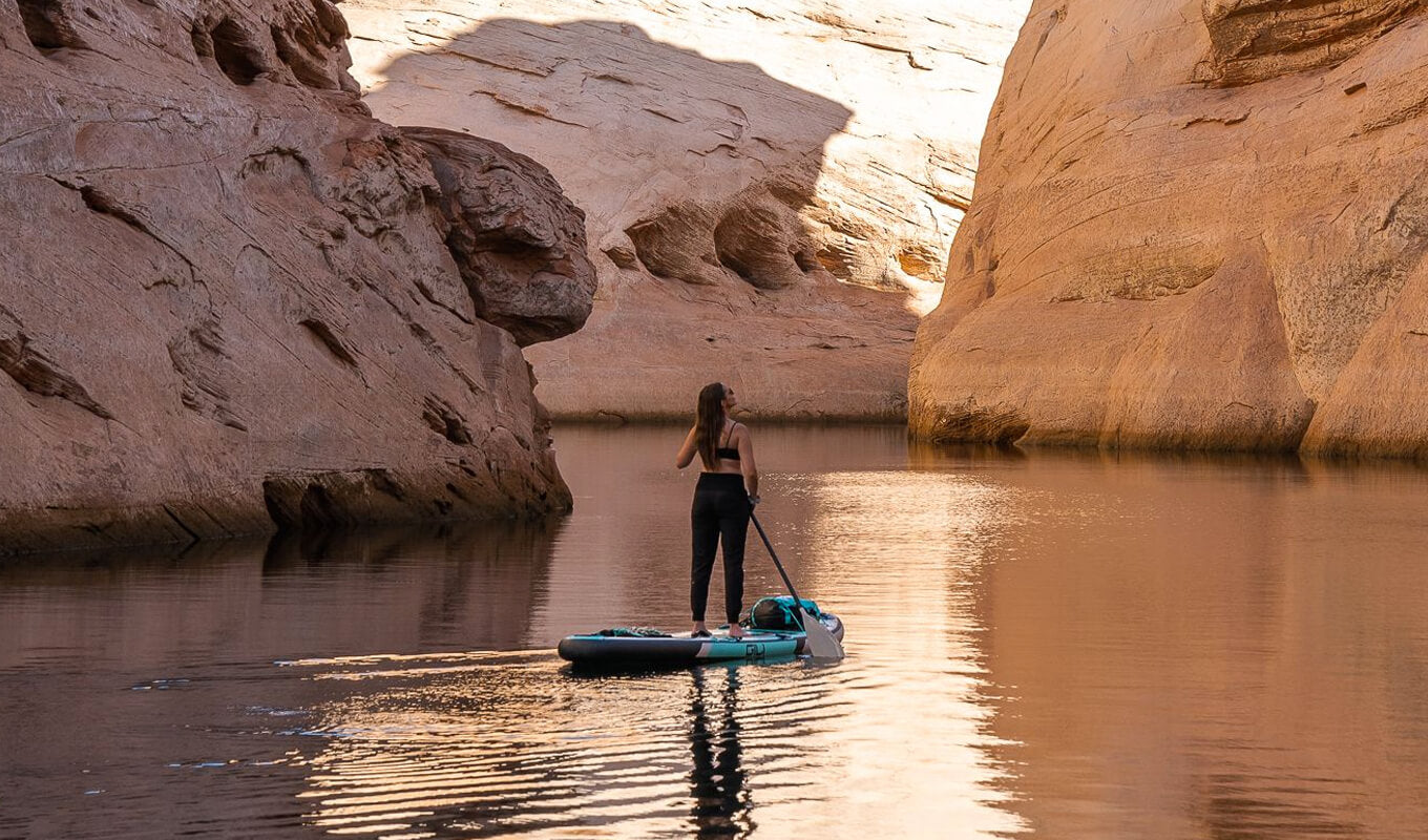 Woman accessing hidden spots on lake powell by paddle board