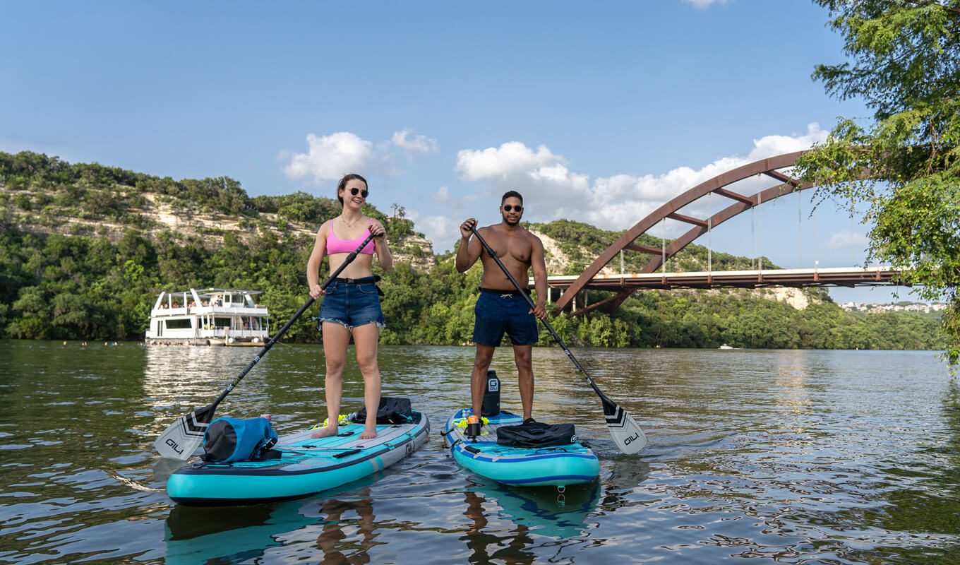 Man and a woman paddle boarding using a GILI inflatable paddle board