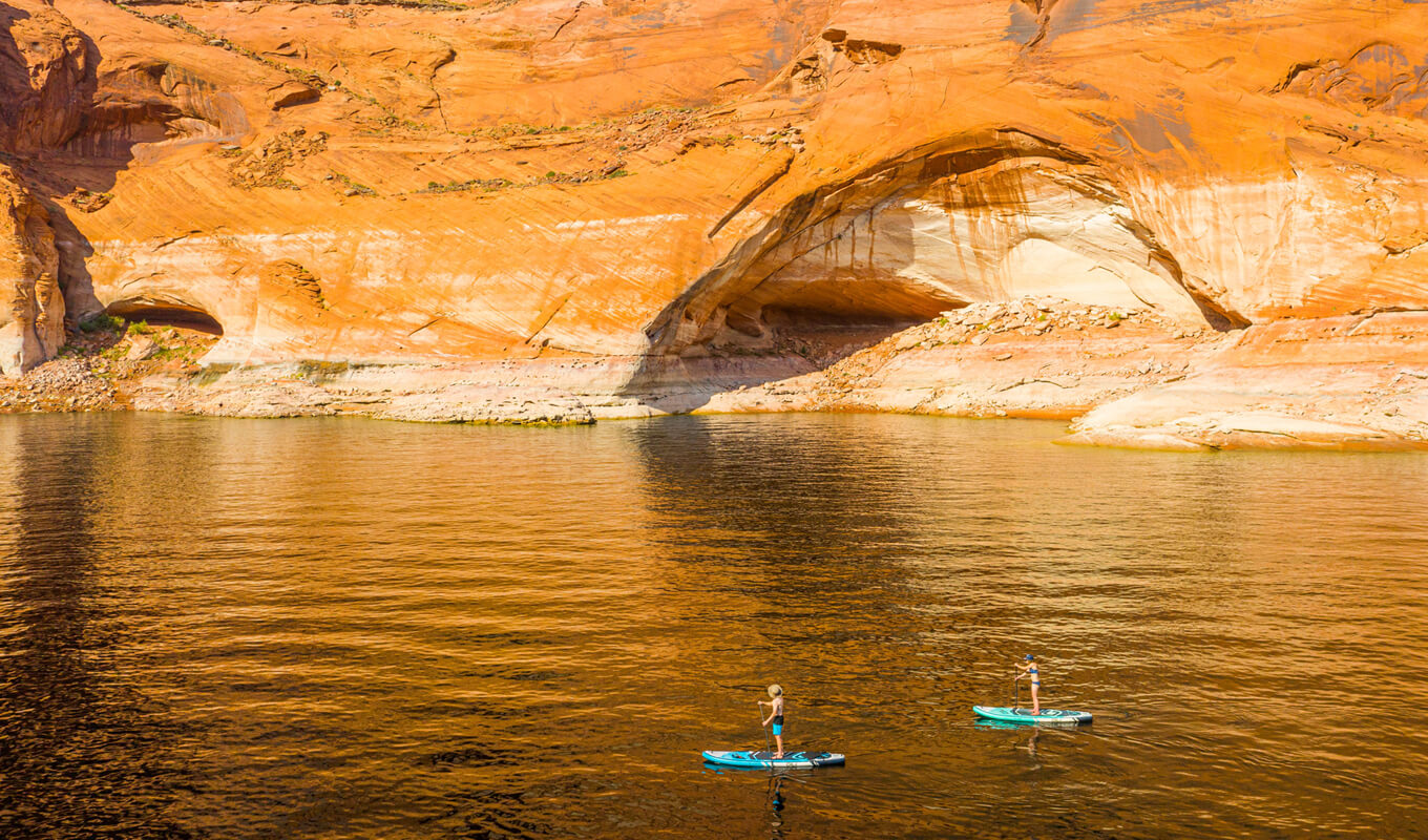 Man and a woman paddle boarding on a lake