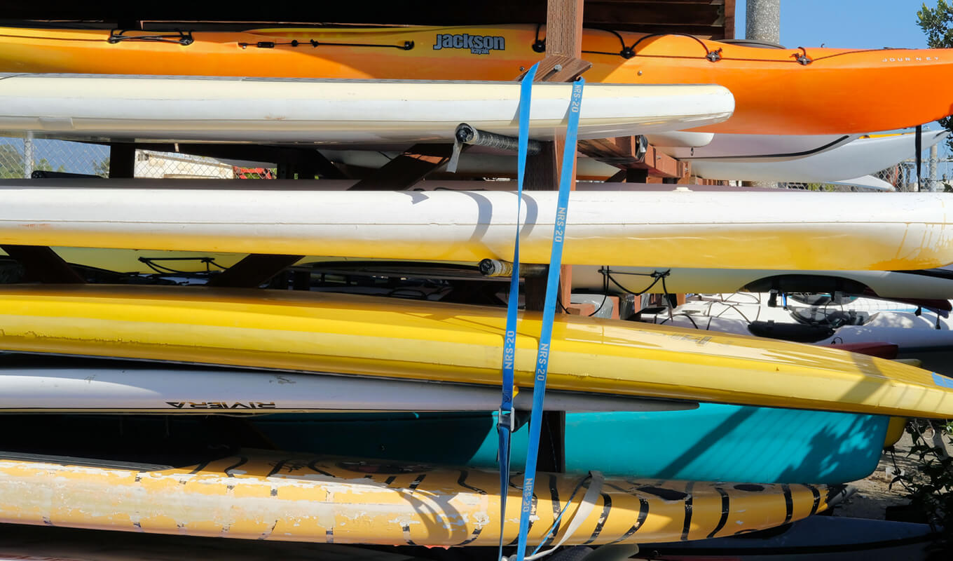 Paddle board stored on a rack outside