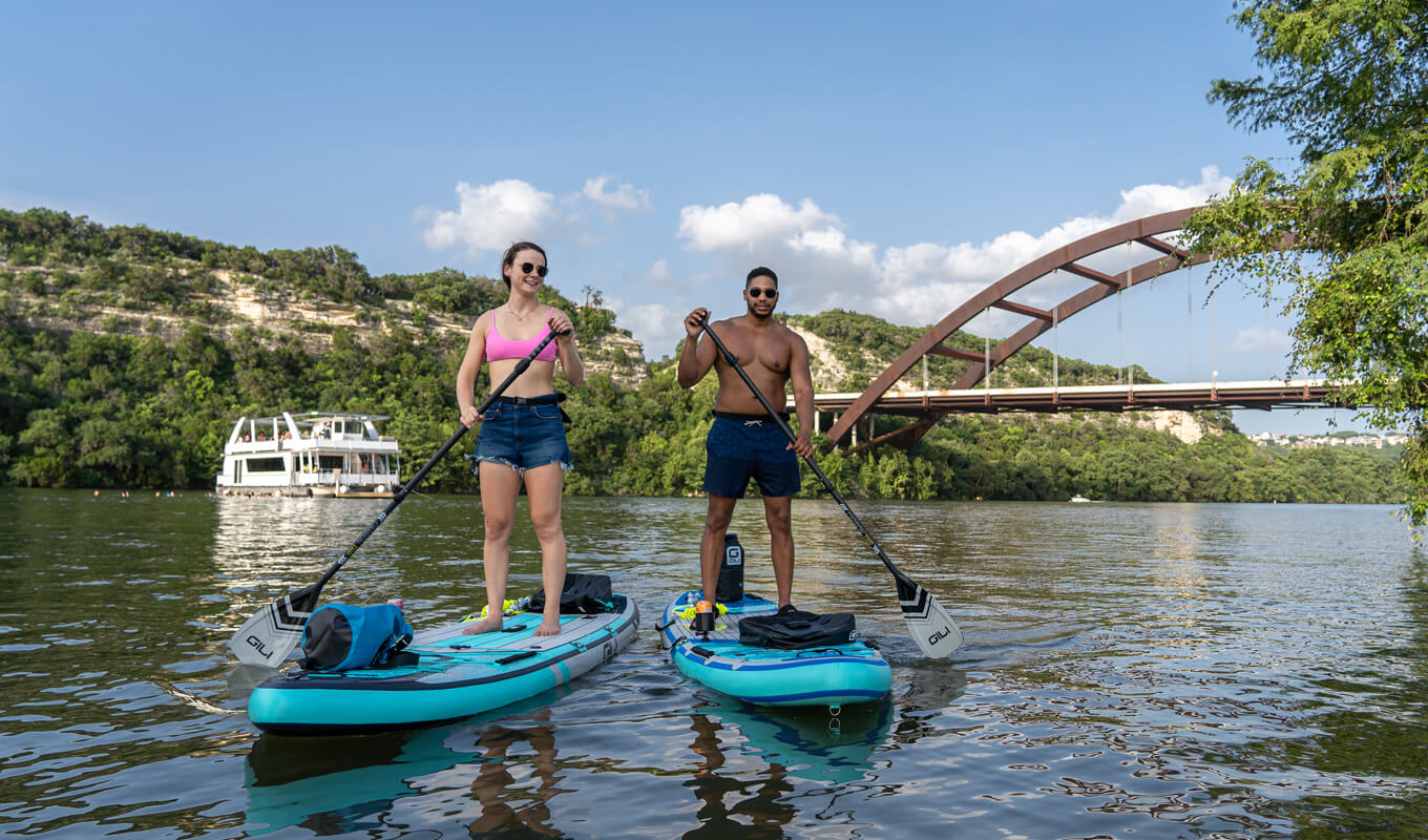 Man and a woman paddle boarding in river