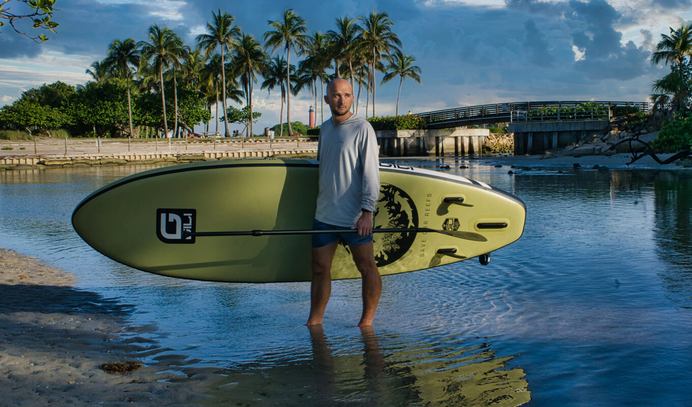 Mann, der sein aufblasbares SUP-Board GILI Meno hält