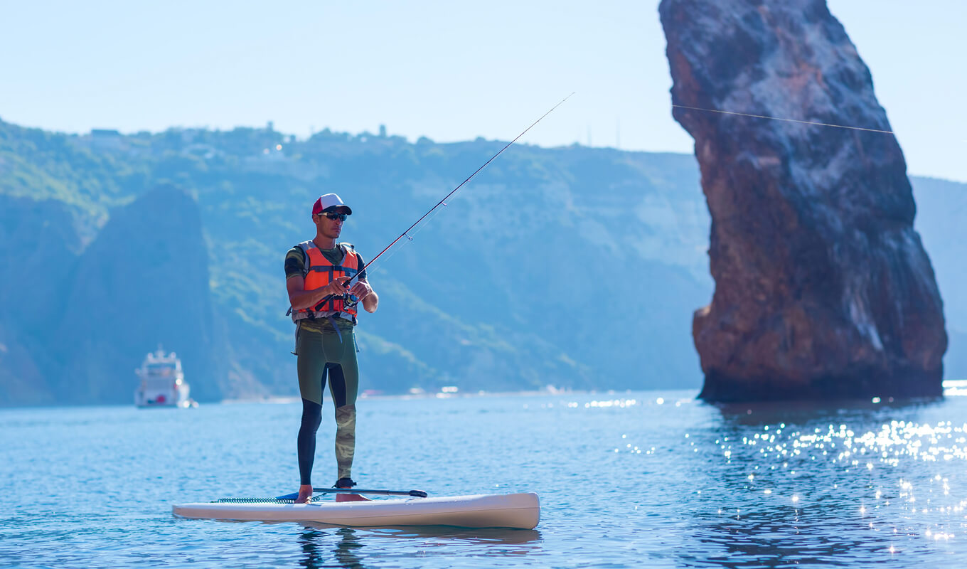 Man fishing using inflatable paddle boards