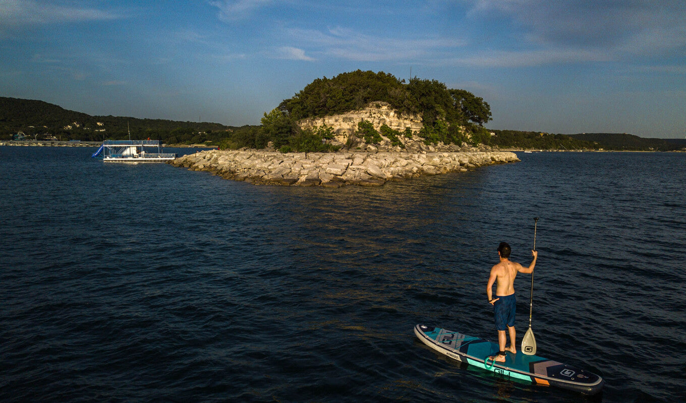 Mann in einem SUP-Board auf einem See