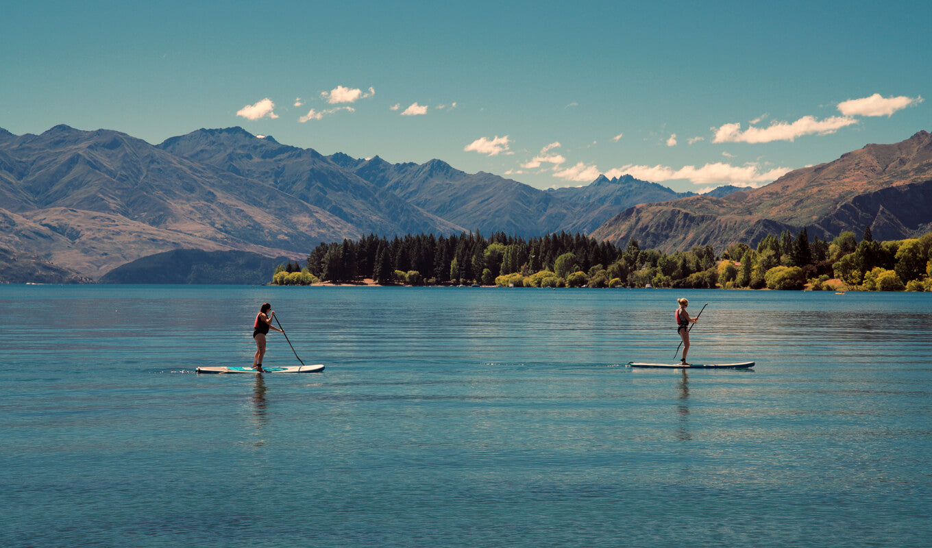 Two people paddle boarding on a lake