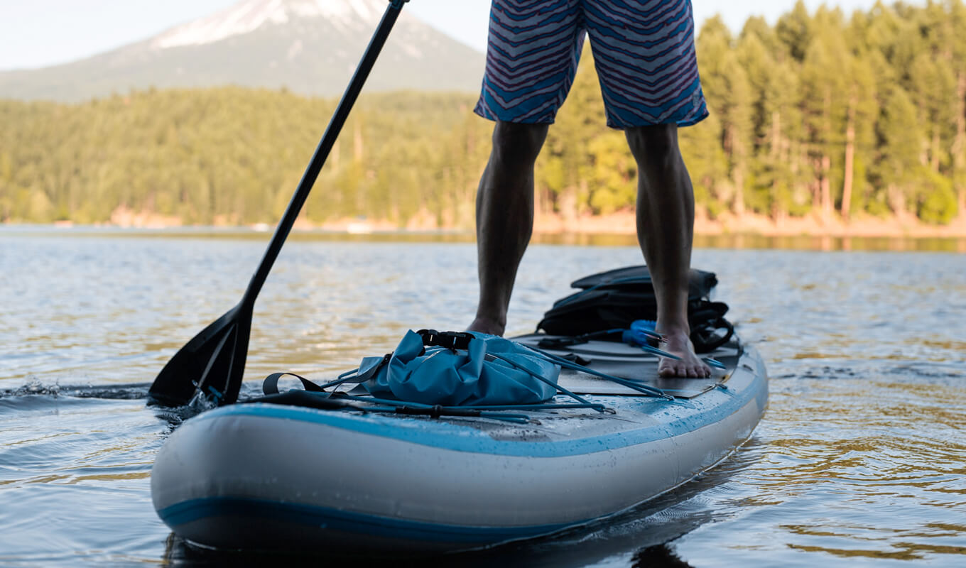 Man paddle boarding with different accessories