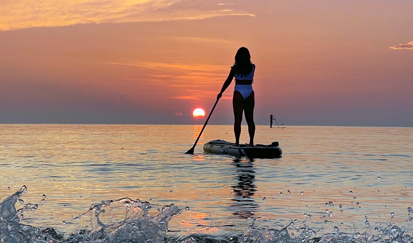 Frau paddelt im Meer