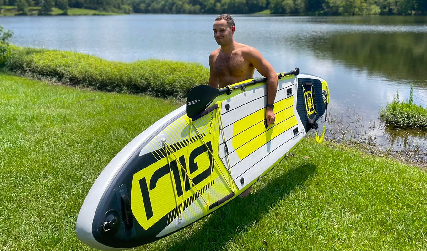 Man carrying a yellow adventure GILI paddle board