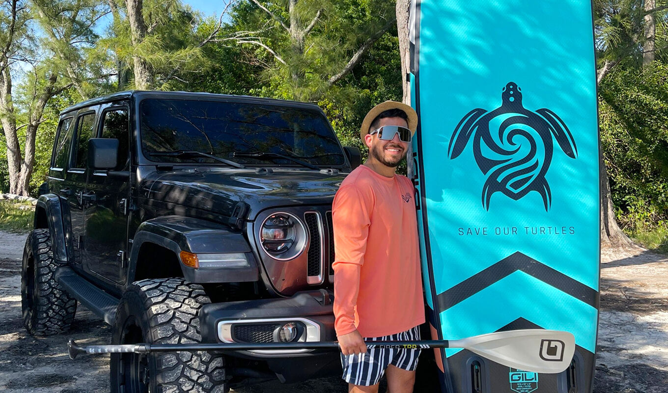 Man standing near a car beside his GILI paddle board