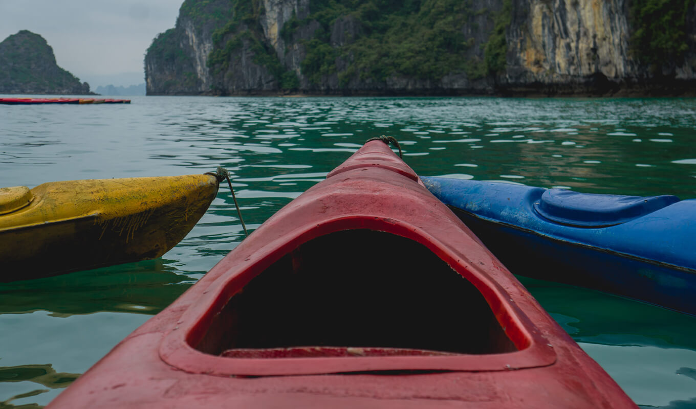 Red, yellow and blue kayak anchored