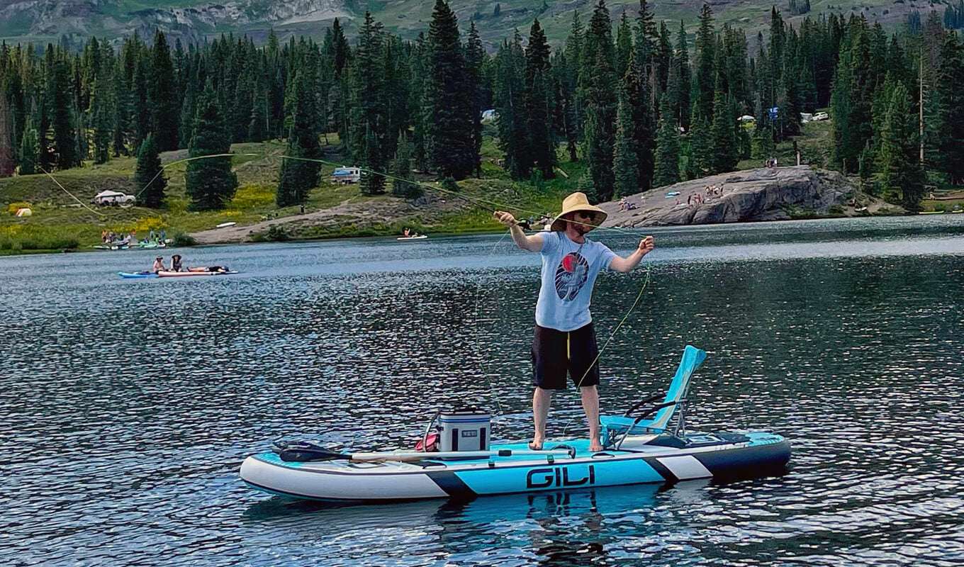 Man paddle board fishing using a blue paddle board