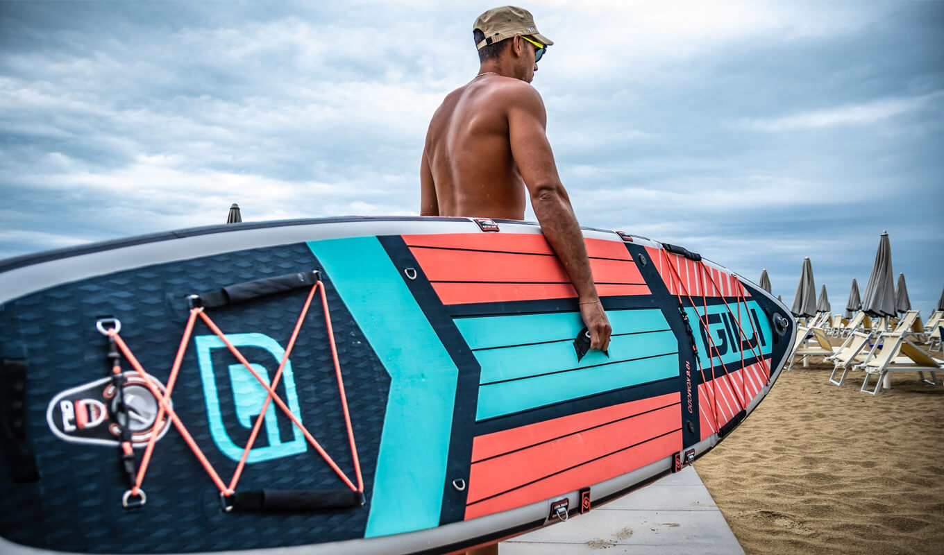 Man carrying his GILI Komodo inflatable paddle board