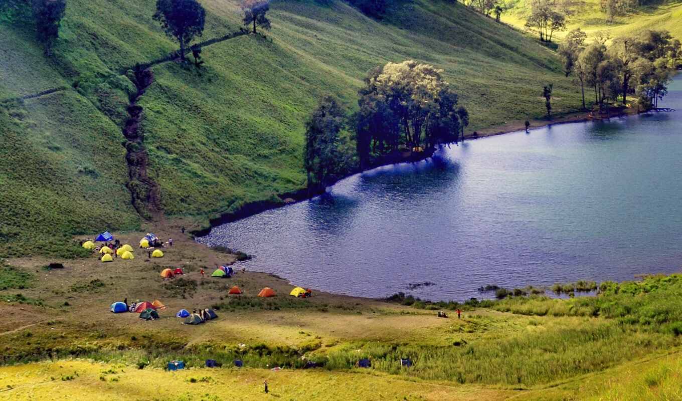 Group of people camping near a lake