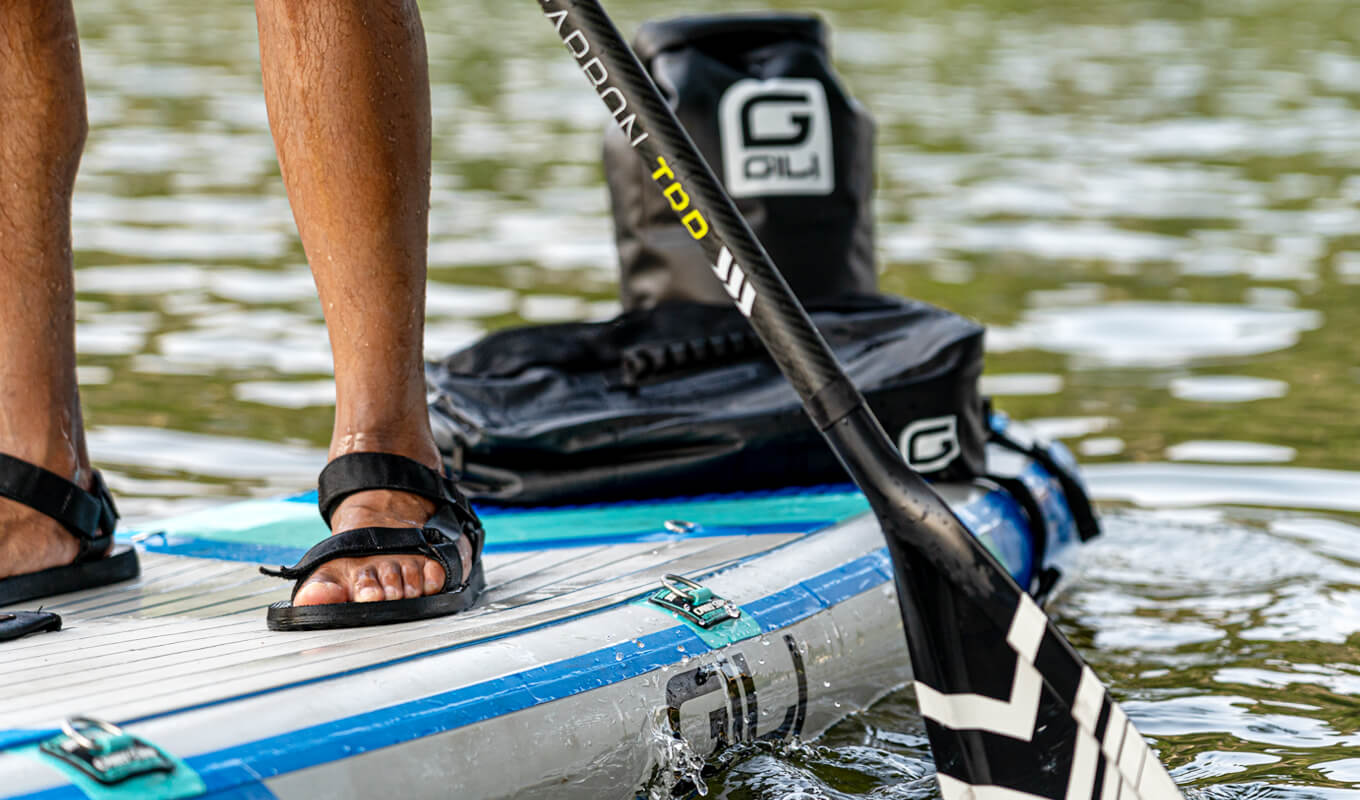 Man paddle boarding with a Gili dry bag