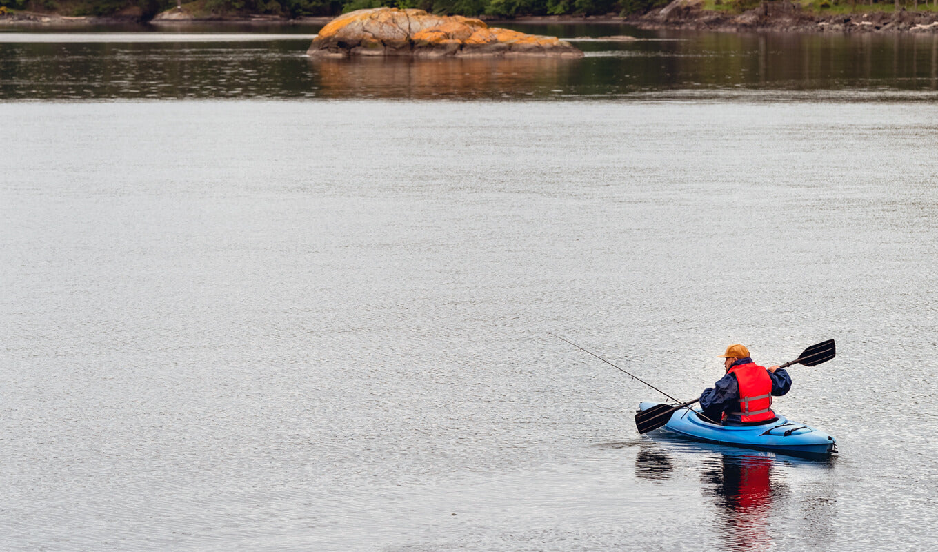 Man on a sit in kayak fishing on a lake