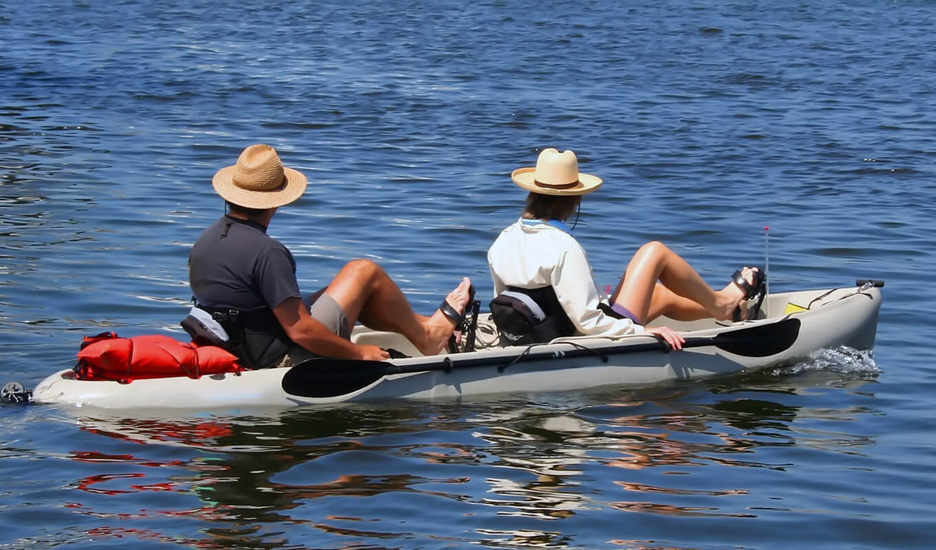 Man and a woman pedal kayaking wearing a paddling jacket