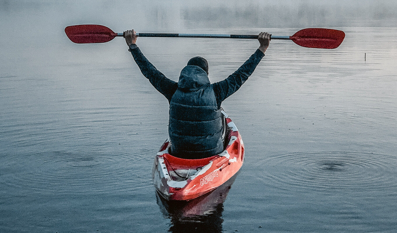 Man wearing a sleeves on a red kayak