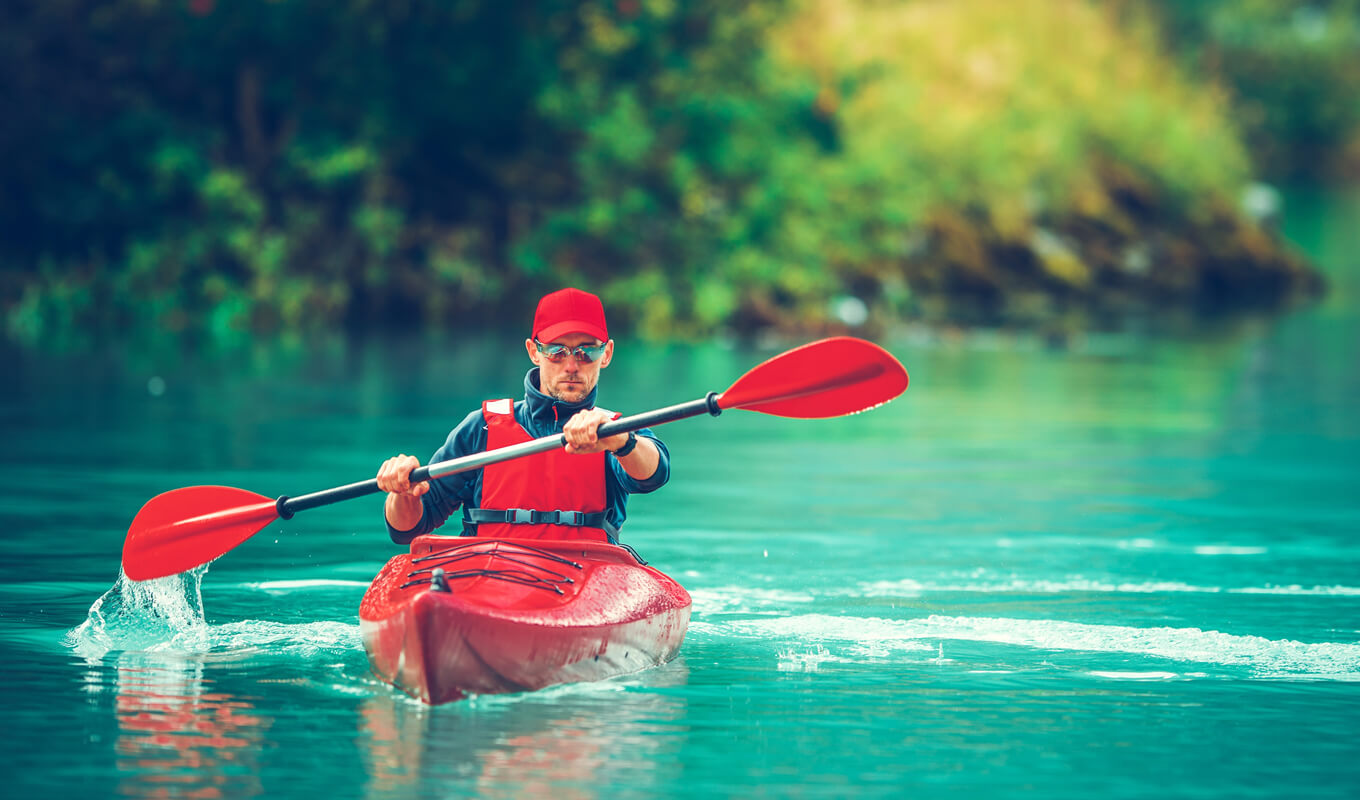Man kayaking on a red sit-in kayak
