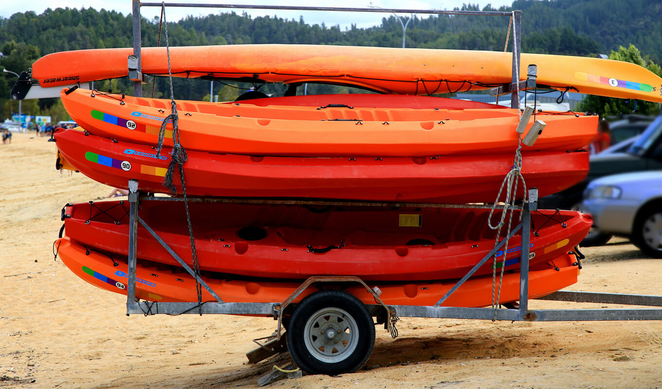 Orange kayak stack on a kayak trailer