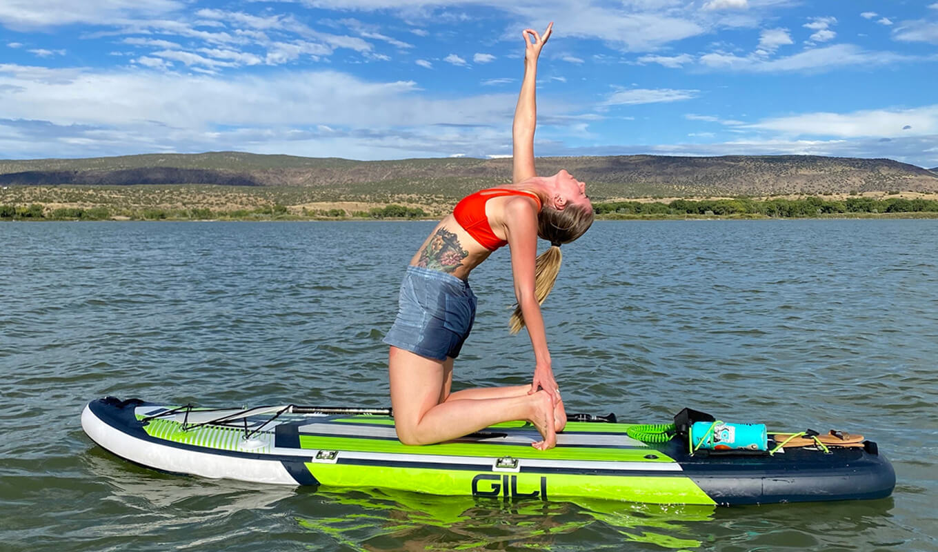 Woman performing yoga on her mako inflatable paddle board